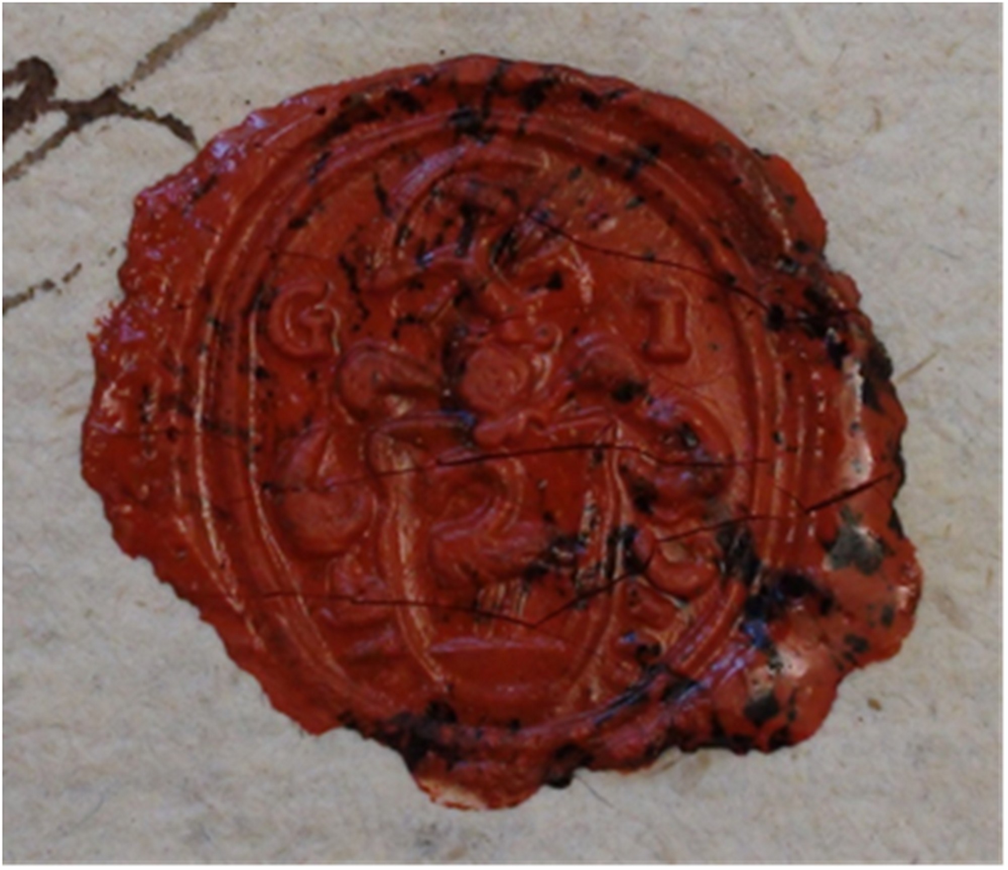 Slika 1: Odtis naprstnega pečatnika županijskega sodnika prisednika Janeza Godine, prva polovica 18. st. V gornjem delu so vidne inicialke G I − Godina Ioannes